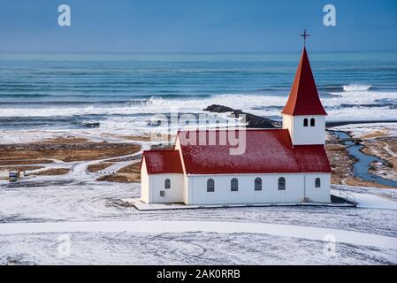 Die malerische Vik i Myrdal Kirche oben auf dem Hügel mit malerischen Bildern auf den Atlantischen Ozean und dem Dorf Vik in Island Stockfoto