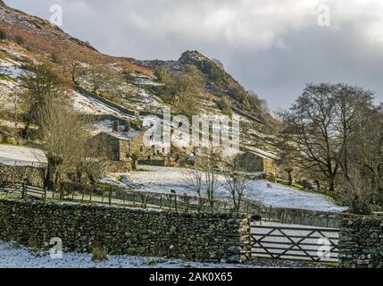 Farm im Winter im Great Langdale Valley Lake District National Park Cumbria. Ein leichtes Schneetreiben bei Sonnenschein. Stockfoto