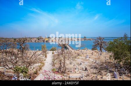 Blick vom Hügel auf der Insel Joal-Fadiout, Senegal. Baobab Bäumen auf dem christlichen Friedhof in Afrika. Es ist die Stadt und lange Holzbrücke. Stockfoto