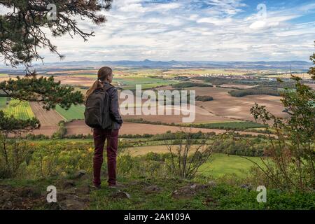 Junge Frau - Wanderer Blick auf ländliche Landschaft mit Dörfern, Feldern und Bergen im Hintergrund, blauer Himmel mit weißen Wolken, Blick vom Rip Berg, Stockfoto