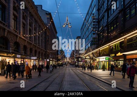 Aleksanterinkatu mit Straßenbahnschienen und Weihnachtsbeleuchtung in Helsinki, Finnland Stockfoto