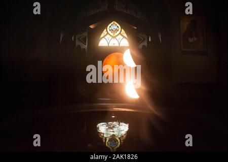 Sonnenlicht und objektiv über die Schrift am Eingang zu einer katholischen Kirche Stockfoto