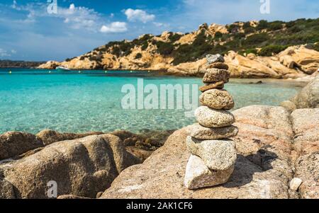 Gestapelte Steine auf die schönsten Strände von Sardinien. Paradies für Ferien. Gestapelte Steine und türkisblauem Wasser. Stockfoto