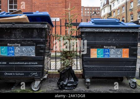 London, Großbritannien. 3. Januar, 2020. Ein Weihnachtsbaum ist neben einigen recycling Bins in East London verworfen. Credit: Guy Corbishley/Alamy leben Nachrichten Stockfoto