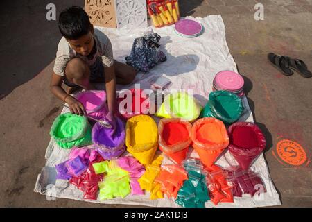 Ein Junge verkaufen in Pulverform Farbe für das Festival von Holi in der Altstadt von Delhi, Indien Stockfoto