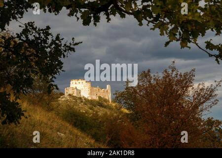 Die riesigen Ruinen von Devicky Castle auf Palava Hills, Riesige Ruinen von Devicky Castle auf Palava-Hügeln, düsterer bewölkter Himmel, Ruinen, die von Herbstsonne angezündet werden Stockfoto