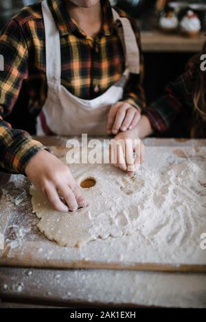 Junge Freunde backen Kekse in der Küche. Nahaufnahme der Arme. Stockfoto