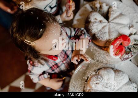 Kleines Mädchen in der Küche. Nase des Kindes in Mehl. Weihnachten Familienfeier Stockfoto