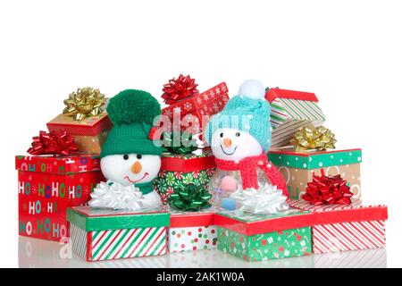 Stapel von kleinen bunten hellen Weihnachten Geschenke mit Bänder und Bögen auf weißem Hintergrund mit Reflexion an der Oberfläche lokalisiert, zwei han Stockfoto