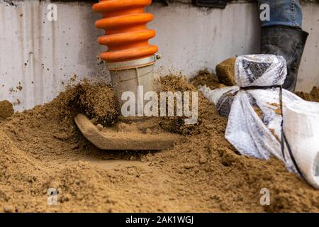 Eine Detailansicht auf der Metallplatte eines schwingenden Rammer, mit Sand springen in die Luft aus dem schweren Aktion der Maschine, Grundlagen und Vorbereitung. Stockfoto