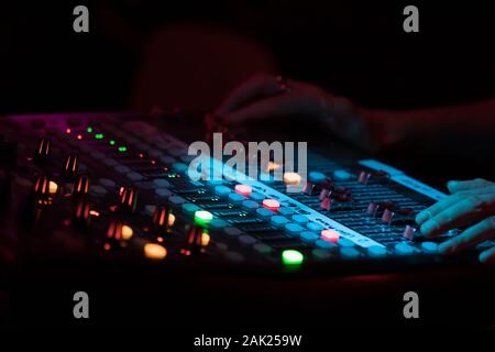 Hände auf ein professionelles Konzert Sound Mixer mit Schiebereglern und Regulierungsbehörden, Audio Stockfoto