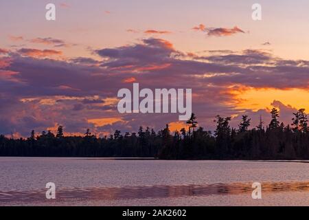 Lila Wolken und Gold Himmel bei Sonnenuntergang auf Caribou Lake in der Boundary Waters in Minnesota Stockfoto