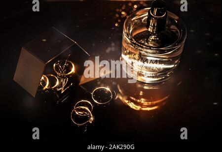 Hochzeit Details, goldene Ringe und Flasche Parfüm Yves Saint Laurent Stockfoto