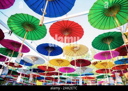 Regenschirm hängen am Himmel mit bunten Hintergrund. Stockfoto