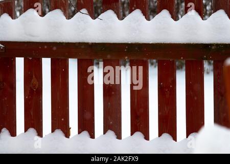 Ländliche Holzzaun bedeckt mit frisch gefallenen Schnee. Stockfoto