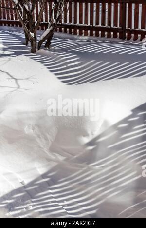 Ländliche Holzzaun bedeckt mit frisch gefallenen Schnee. Stockfoto