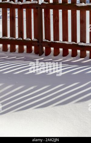 Ländliche Holzzaun bedeckt mit frisch gefallenen Schnee. Stockfoto