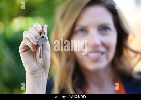 Real Estate Agent Frau Lächelt Mit Schlüsseln in der Hand