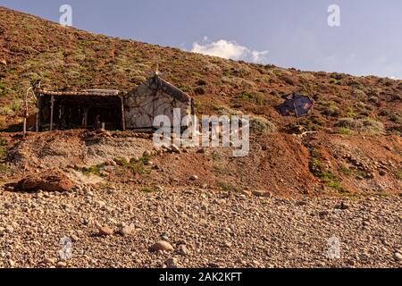 Hütte von einem Fischer, Aufbau der Steine und Müll in die Klippe Stockfoto