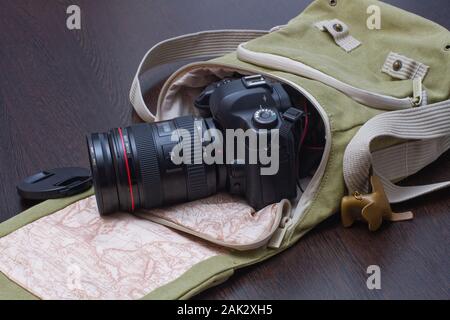 Reisetasche für ein Fotograf mit einer Kamera in der es auf einem roten Baum Stockfoto