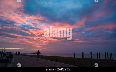 Brighton UK 7. Januar 2020 - Läufer genießt einen wunderschönen Sonnenaufgang über Brighton Beach und das Meer heute morgen als den nassen und windigen Wetter Prognose ist in Großbritannien in den nächsten Tagen zu verbreiten. Foto: Simon Dack/Alamy leben Nachrichten Stockfoto