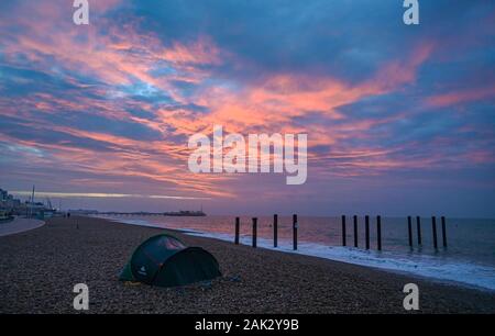 Brighton UK 7. Januar 2020 - ein Heimatloser Zelt auf Brighton Beach bei einem wunderschönen Sonnenaufgang über den Strand und das Meer heute morgen als den nassen und windigen Wetter Prognose ist in Großbritannien in den nächsten Tagen zu verbreiten. Foto: Simon Dack/Alamy leben Nachrichten Stockfoto