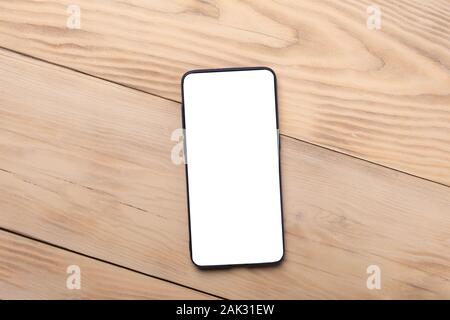Smartphone mockup mit weißer Bildschirm auf Holz- Hintergrund. Flach, Ansicht von oben. Stockfoto