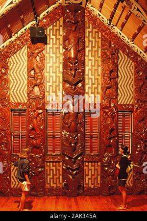 Besucher im Hinblick auf die geschickte Schnitzereien in der Waitangi Haus, Haus der Begegnung der Maori in Waitangi. Hier im Jahre 1840 den Vertrag von Waitangi war wa Stockfoto