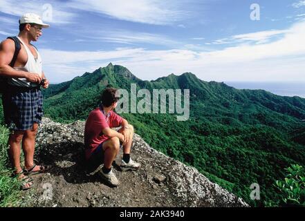 Wanderer genießen die Aussicht vom Te Rua Manga auf der Insel Rarotonga. Der Berg hat eine Höhe von 413 Meter. Aufgrund seiner stacheligen Form der Felsen Stockfoto