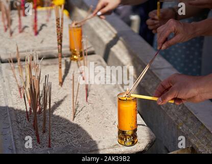 Buddhistische Gläubige sind Beleuchtung Räucherstäbchen in einem Schrein im Grand Palace in Bangkok, Thailand Stockfoto