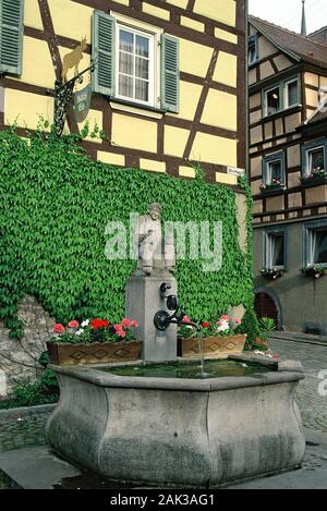 Ein Brunnen steht auf einem Platz in der malerischen Altstadt von Weikersheim. Es ist von Fachwerkhäusern umgeben. Weikersheim ist in der Regi entfernt Stockfoto