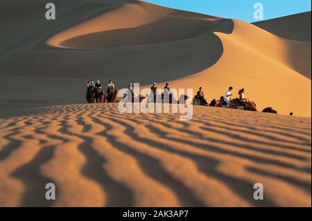 Touristen die Teilnahme an einer Reise durch die Wüste von Mingsha Shan (Jingling Sand Hill) in der Nähe von Dunhuang. Sanddünen mit einer Höhe von Mor Stockfoto