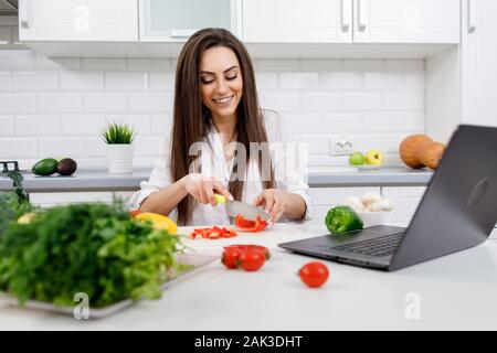 Süße Hausfrau Kochen nach dem Internet Rezepte Stockfoto