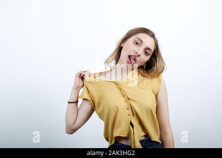 Verrückte Frau zieht Shirt Rückseite mit Fingern, sich selbst Erdrosseln, zeigt Zunge Stockfoto