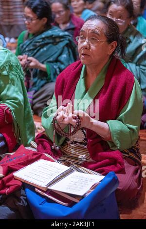 Einem frommen buddhistischen worshipper rezitierten Gebete während der Verwendung der richtigen Position. Bei einem Tsu Che Puja an einem Tempel in Elmhurst, Queens, New York City. Stockfoto