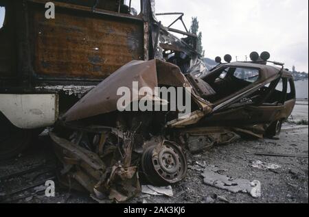 17. August 1993 während der Belagerung von Sarajevo: Aus dem ersten 'Krieg' des Krieges Anfang Mai 1992 eine verstümmelte Polizei Auto, stürzte in eine Straßenbahn, beide Fahrzeuge ausgebrannten und Rost. Stockfoto