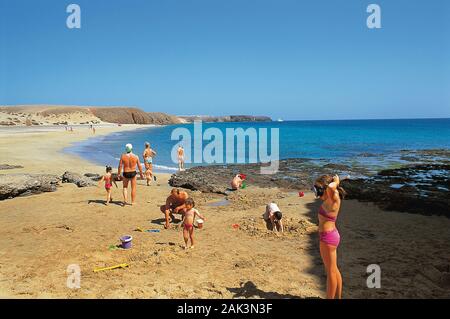 Urlauber an der Playa de Papagayo in der Nähe von Playa Blanca auf der spanischen Insel Lanzarote. Die so genannte Parrot Strände sind durch picturesq gekennzeichnet Stockfoto