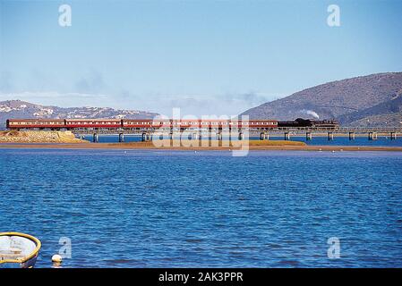 Mit der Outeniqua Choo Tjoe Train, einer schmalen Dampf Eisenbahn Spur, es beginnt, von George an der Küste entlang und über die Lagune von Knysna in der Stockfoto