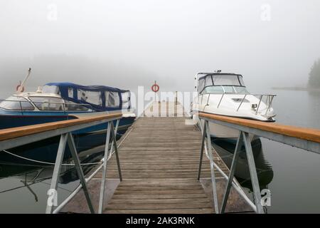 Motorboote, Yachten und Boote Rest in der Nähe der Pier in einer nebligen Morgen Stockfoto