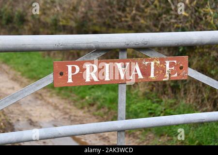 Ein braunes Holz Schild privat auf einem Metall farm Gate Stockfoto