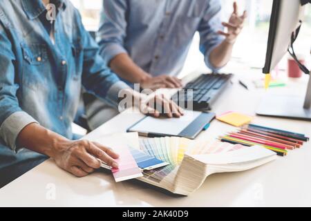 Professionelle Kreative Architekten Grafik desiner Besetzung die Wahl der Farbe Pantone-palette Proben für Projekt auf Office Desktop Computer. Stockfoto