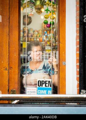 Stern Suche alte Frau Krämer schaut aus Handwerk Schaufenster in New Orleans Stockfoto