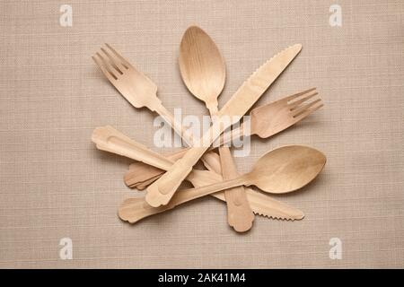 Zwei Sätze der natürlichen handgefertigten Besteck angeordnet wie ein Stillleben mit Messer, Gabel und Löffel auf einem beigen Hintergrund legen Stockfoto