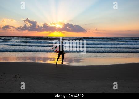 Silhouette von Surfer am Strand des Mittelmeers. In Tel Aviv bei Sonnenuntergang fotografiert. Stockfoto