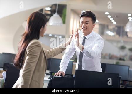 Chinesische Geschäftsleute geben hohe fünf im Büro Stockfoto