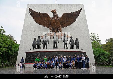 Jakarta, Indonesien - 2019.12.20: Ein schoolclass von Mädchen und Jungen für ein Foto auf die Pancasila sakti Denkmal auf dem gescheiterten Putsch von 1965 posing Stockfoto