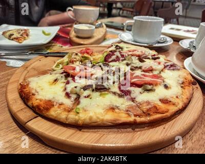 Runde pide oder türkische Pizza mit Käse, Sujuk und verschiedene Fleischsorten auf einem hölzernen Fach selektiven Fokus. kleine Schwerpunkt Stockfoto