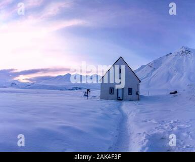 Kirche auf dem verschneiten Cross Pass auf die georgische Armee Autobahn während des Sonnenuntergangs. Georgien Stockfoto