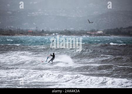 Athen, Griechenland. 6. Januar, 2020. Ein Surfer surft mit starken Winden in Lavrio, Griechenland, Jan. 6, 2020. Die Kaltfront brachte starker Schneefall, Frost, Stürme und starke Winde in vielen Teilen des Landes. Credit: Lefteris Partsalis/Xinhua/Alamy leben Nachrichten Stockfoto