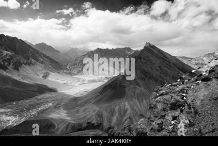 Spiti Spiti Fluss schlängelt sich durch das Tal, das von den hohen Gipfeln des Himalaya und Buddhistische Gebetsfahnen in der Nähe von Kaza, Himachal Pradesh, Indien flankiert. Stockfoto